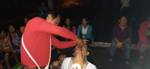 kichwa traditional healer using mapacho tobacco for treating a sick patient